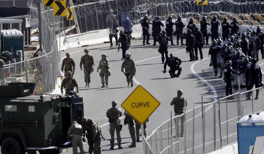 FILE - In this Sunday, Nov. 25, 2018, file photo, military personnel and Customs and Border Protection officers gather along the southbound lanes of the San Ysidro port of entry in San Diego. The number of immigrants in the U.S. without legal status has declined to its lowest level in more than a decade, according to a new report released Tuesday. (AP Photo/Gregory Bull, File)
