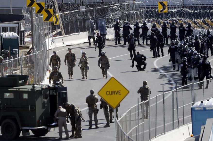 FILE - In this Sunday, Nov. 25, 2018, file photo, military personnel and Customs and Border Protection officers gather along the southbound lanes of the San Ysidro port of entry in San Diego. The number of immigrants in the U.S. without legal status has declined to its lowest level in more than a decade, according to a new report released Tuesday. (AP Photo/Gregory Bull, File)