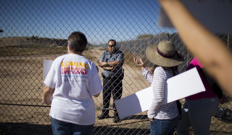 In this Nov. 15, 2018 photo provided by Ivan Pierre Aguirre, protesters talk to a guard inside the Tornillo detention camp holding more than 2,300 migrant teens in Tornillo, Texas. The Trump administration announced in June 2018 that it would open the temporary shelter for up to 360 migrant children in this isolated corner of the Texas desert. Less than six months later, the facility has expanded into a detention camp holding thousands of teenagers - and it shows every sign of becoming more permanent. (Ivan Pierre Aguirre via AP)