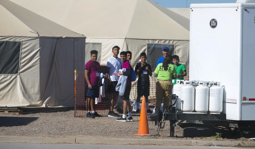In this Nov. 15, 2018 photo provided by Ivan Pierre Aguirre, migrant teens held inside the Tornillo detention camp look at protestors waving at them outside the fences surrounding the facility in Tornillo, Texas. The Trump administration announced in June 2018 that it would open the temporary shelter for up to 360 migrant children in this isolated corner of the Texas desert. Less than six months later, the facility has expanded into a detention camp holding thousands of teenagers - and it shows every sign of becoming more permanent. (Ivan Pierre Aguirre via AP)