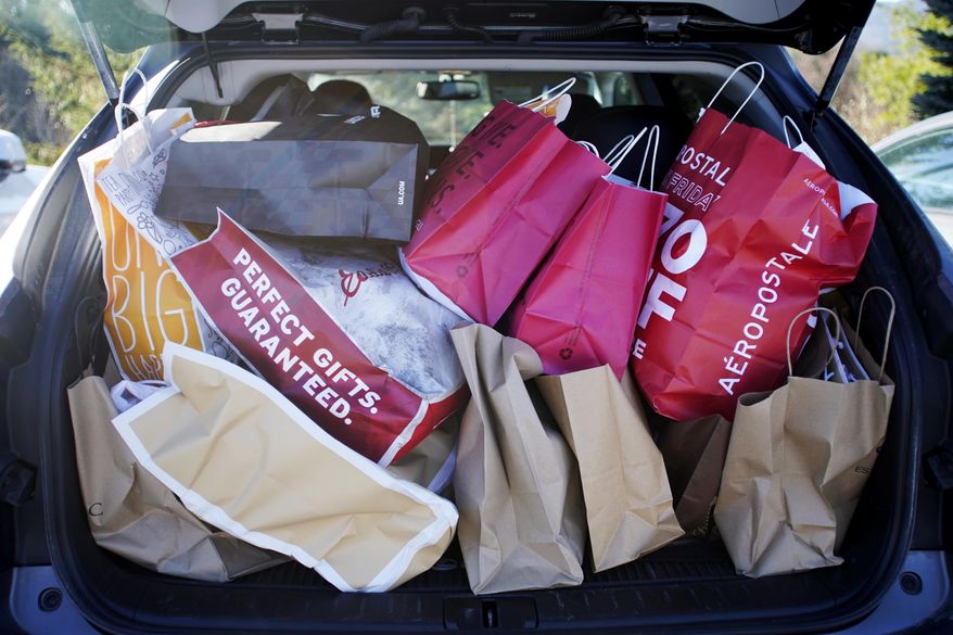 FILE- In this Nov. 23, 2018, file photo shopping bags are stuffed into a car at Prime outlets on Black Friday in Lee, Mass. Last year, 65 percent of millennial shoppers put gifts on their credit card. This year, roughly a third of them are still paying off that debt, according to an annual survey of holiday shoppers from NerdWallet. (Ben Garver/The Berkshire Eagle via AP, File)