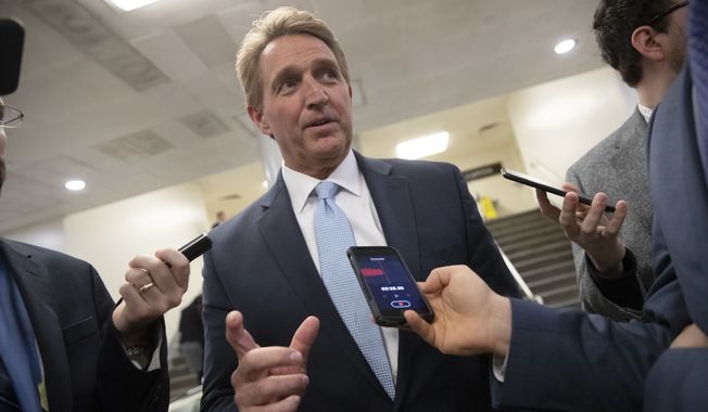 In this file photo, Sen. Jeff Flake, R-Ariz., speaks with reporters before he and Sen. Chris Coons, D-Del., try to bring up the legislation to protect special counsel Robert Mueller, at the Capitol in Washington, Wednesday, Nov. 14, 2018. On June 20, 2019, the AP reported Mr. Flake, now retired from the Senate, will be a visiting fellow at Harvard University in the fall. (AP Photo/J. Scott Applewhite) **FILE**