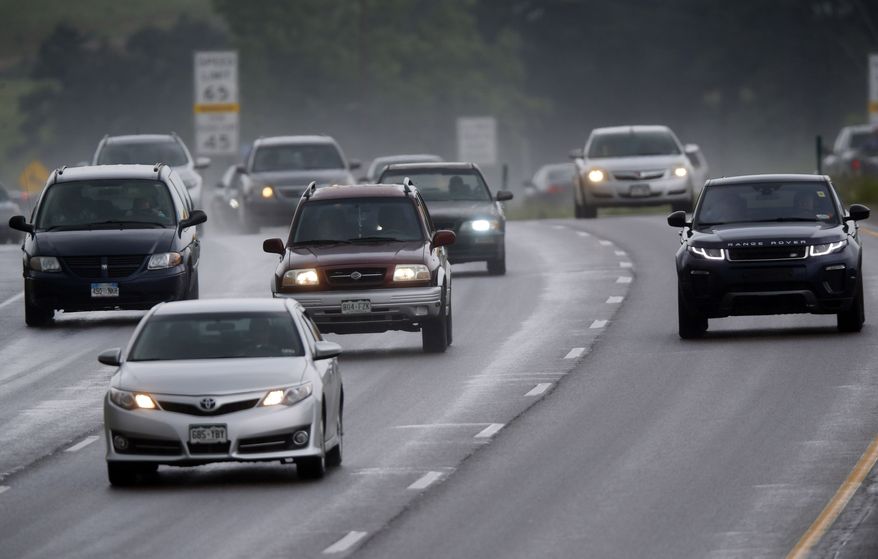 Motorists guide their vehicles down Interstate 70 through heavy traffic and light rain as Independence Day revelers return from the mountains Sunday, July 5, 2015, in Evergreen, Colo. Motorists suffered through hour or more delays due to heavy volume of traffic on the highway Sunday as the Fourth of July weekend comes to a close. (AP Photo/David Zalubowski)