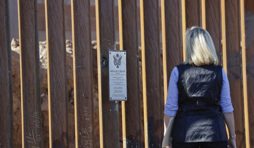 FILE- In this Oct. 26, 2018, file photo U.S. Department of Homeland Security Secretary Kirstjen Nielsen takes a look at a plaque adorning a newly fortified border wall structure in Calexico, Calif. In a Wednesday, Nov. 28, letter to the heads of the Department of Health and Human Services and the Department of Homeland Security, 112 civil liberties and immigrant rights groups, child welfare advocates and privacy activists are crying foul, demanding an immediate halt to what they call an illegal practice. HHS and DHS are obtaining information from detained children on their U.S.-based relatives for reunification, the authors complain, and “using that data to find, arrest and deport those families.” Already, they write, “families have become too scared to step forward to sponsor children.” (AP Photo/Gregory Bull, File)