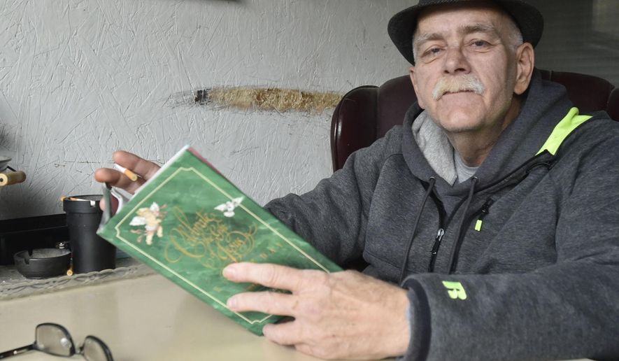 This photo taken Nov. 2, 2018, shows Jon Duchac reading from a book of meditations, reflecting on the medical hardships he's struggled through to get to where he is now: awake, alert, and seemingly seizure-free. (Pete Wicklund/The Journal Times via AP)