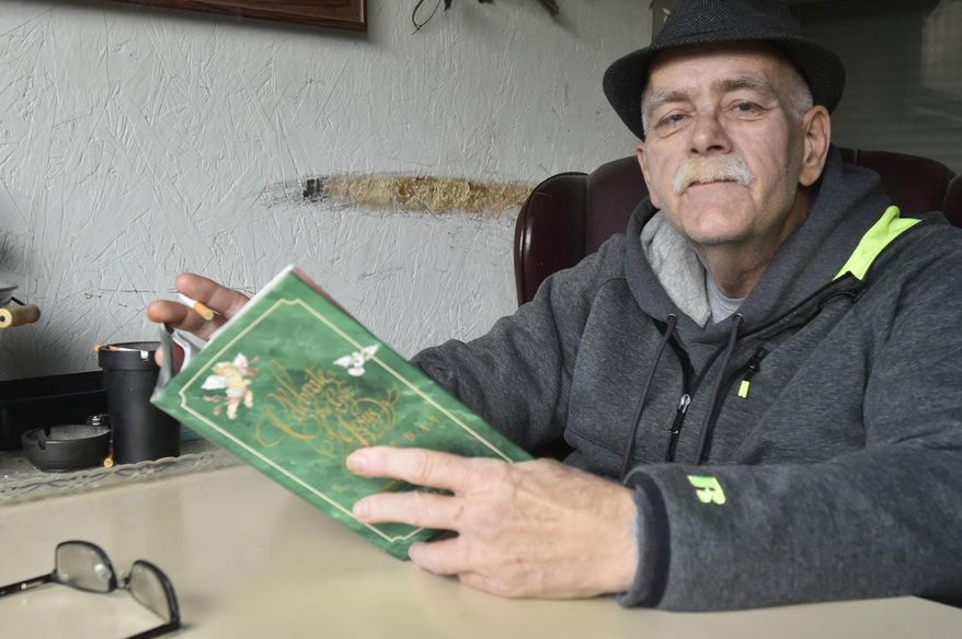 This photo taken Nov. 2, 2018, shows Jon Duchac reading from a book of meditations, reflecting on the medical hardships he's struggled through to get to where he is now: awake, alert, and seemingly seizure-free. (Pete Wicklund/The Journal Times via AP)