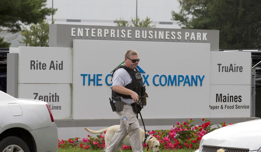 FILE - In this Sept. 20, 2018, file photo, ATF police officer with a sniffing dog walks out the industrial complex in Harford County, Md. The girlfriend of Snochia Moseley, who gunned down three co-workers at a Maryland warehouse, told investigators that her companion was prone to violent outbursts, heard voices in her head and had threatened her with a gun before September’s rampage, according to a police report obtained by The Associated Press. (AP Photo/Jose Luis Magana, File)