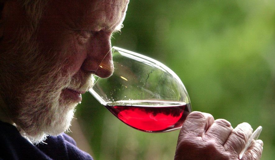 FILE--In this Feb. 23, 2004, file photo, winemaker David Lett savors the bouquet from a glass of Pinot Noir at his Eyrie Vinyards home in Dundee, Ore. Officials in Oregon and at a U.S. government agency are similarly finicky, and have told a California winery to back off its claims it makes an Oregon pinot noir. (AP Photo/Don Ryan, file)