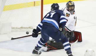 Winnipeg Jets&#39; Nikolaj Ehlers (27) scores on Chicago Blackhawks goaltender Corey Crawford (50) during the first period of an NHL hockey game Thursday, Nov. 29, 2018, in Winnipeg, Manitoba. (John Woods/The Canadian Press via AP)