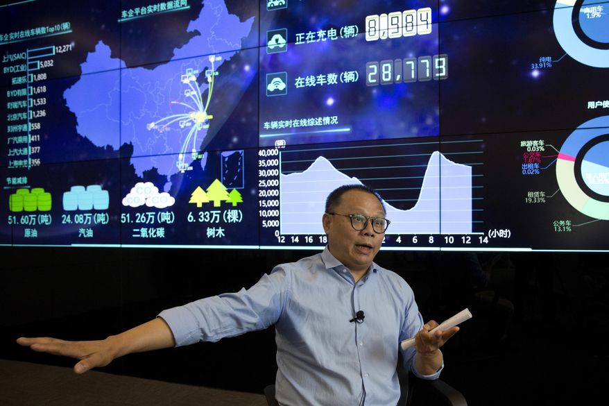 In this Friday, June 22, 2018, photo, Ding Xiaohua, deputy director of the Shanghai Electric Vehicle Public Data Collecting, Monitoring and Research Center speaks near a data display screen in Shanghai. According to specifications published in 2016, every electric vehicle in China transmits data from the car's sensors back to the manufacturer. From there, automakers send 61 data points, including location and details about battery and engine function to local centers like the one Ding oversees in Shanghai. (AP Photo/Ng Han Guan)