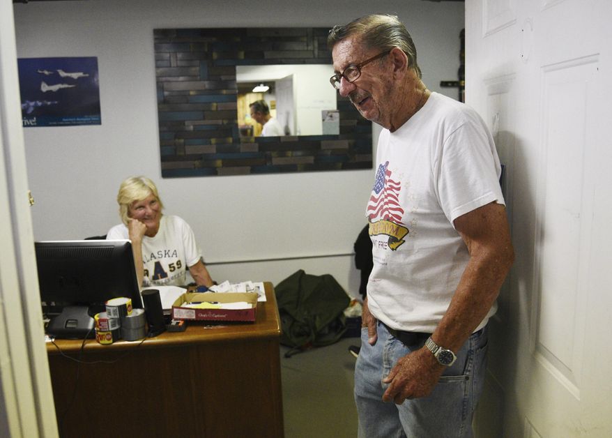 In this Aug. 2, 2018 photo, Russ "Pops" McCann brings a smile to the face of director Mary Carmody at the Midwest Veterans Closet in North Chicago, Ill. McCann has spent many weekdays for about the past four years volunteering at the Midwest Veterans Closet doing wherever needed. He has found a renewed sense of purpose at the nonprofit, which provides veterans and their families with clothing, household items, shoes, boots and other basic needs, as well as housing and employment assistance, at no cost. (Paul Valade/Daily Herald, via AP)