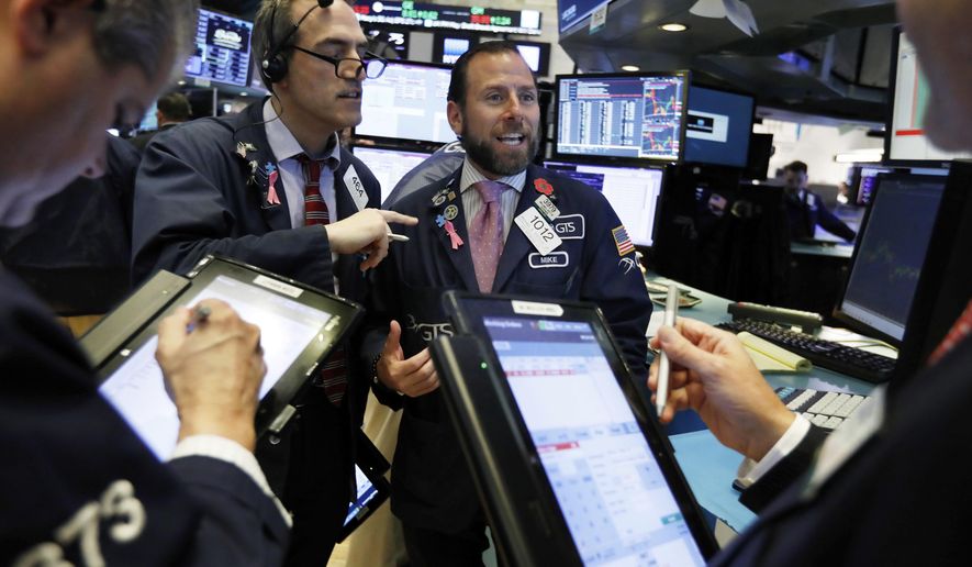 FILE- In this Nov. 14, 2018, file photo specialist Michael Pistillo center, works with traders at is post on the floor of the New York Stock Exchange. The U.S. stock market opens at 9:30 a.m. EST on Thursday, Nov. 29 (AP Photo/Richard Drew, File)