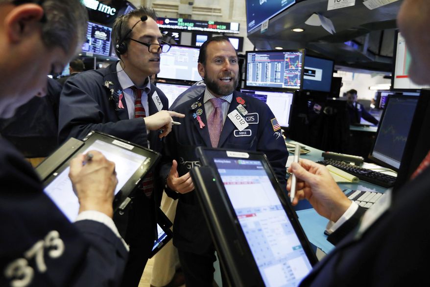 FILE- In this Nov. 14, 2018, file photo specialist Michael Pistillo center, works with traders at is post on the floor of the New York Stock Exchange. The U.S. stock market opens at 9:30 a.m. EST on Thursday, Nov. 29 (AP Photo/Richard Drew, File)