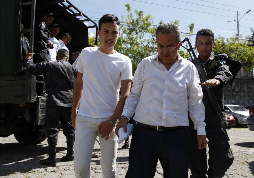 Elvin Rapalo, left, and Sergio Rodriguez, accused in the murder of Honduran indigenous and environmental rights activist Berta Caceres, are led in handcuffs to court by police in Tegucigalpa, Honduras, Thursday, Nov. 29, 2018. Rapalo, Rodriguez and other five accused were found guilty by a court and will be sentenced on January 2019. (AP Photo/Fernando Antonio)
