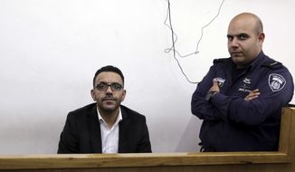 Israeli policeman stand by a Palestinian governor of Jerusalem Adnan Ghaith during a court appearance following his arrest in Jerusalem. Lawyer Rami Othman says the court will hold the Palestinians&#39; Jerusalem governor Adnan Ghaith in custody until Sunday for interrogation.(AP Photo/Mahmoud Illean)