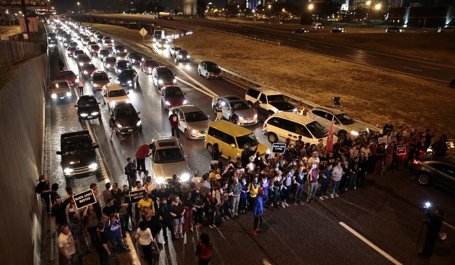 FILE - In this Oct. 3, 2017, file photo, protesters stop traffic on Interstate 64 (Highway 40) eastbound at the Compton Avenue overpass in St. Louis, as part of ongoing demonstrations against the acquittal of a white former police officer in the 2011 killing of a black man. Three St. Louis police officers were indicted Thursday, Nov. 29, 2018, for allegedly beating an undercover colleague during a 2017 protest and, along with a fourth officer, conspiring to cover up the crime. (Robert Cohen/St. Louis Post-Dispatch via AP, File)