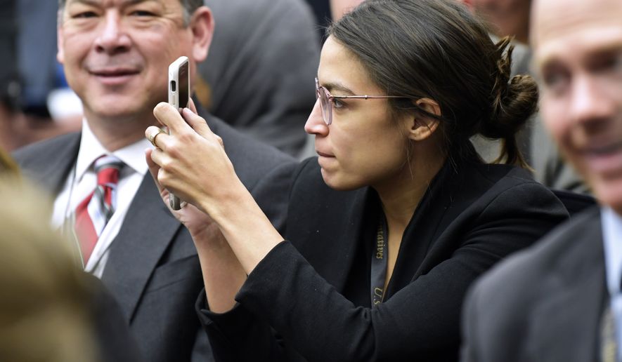 Rep.-elect Alexandria Ocasio-Cortez, D-N.Y., takes a photo as she attends the Member-elect room lottery draw on Capitol Hill in Washington, Friday, Nov. 30, 2018. The lottery determines the order in which new member gets to select their new Capitol Hill office. (AP Photo/Susan Walsh)