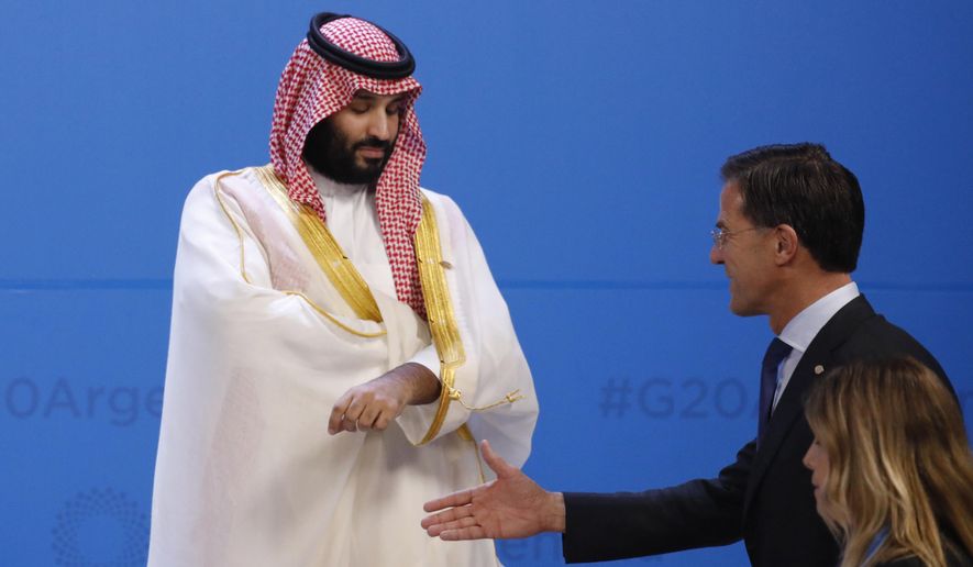 The Netherlands&#39; Prime Minister Mark Rutte, right, extends his hand to greet Saudi Arabia&#39;s Crown Prince Mohammed bin Salman as leaders gather for the group photo during the Group of 20 summit at the Costa Salguero Center in Buenos Aires, Argentina, Friday, Nov. 30, 2018. (Andres Martinez Casares/Pool Photo via AP)