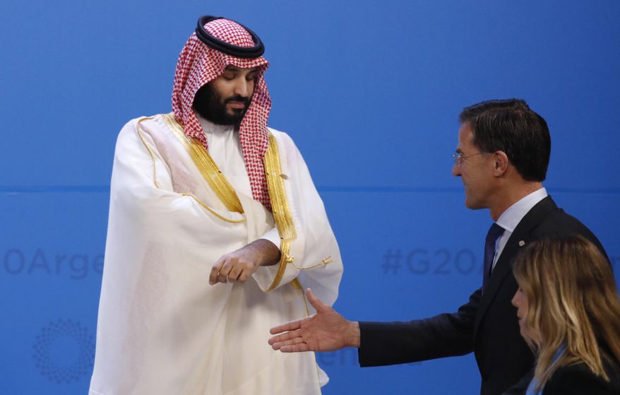 The Netherlands' Prime Minister Mark Rutte, right, extends his hand to greet Saudi Arabia's Crown Prince Mohammed bin Salman as leaders gather for the group photo during the Group of 20 summit at the Costa Salguero Center in Buenos Aires, Argentina, Friday, Nov. 30, 2018. (Andres Martinez Casares/Pool Photo via AP)