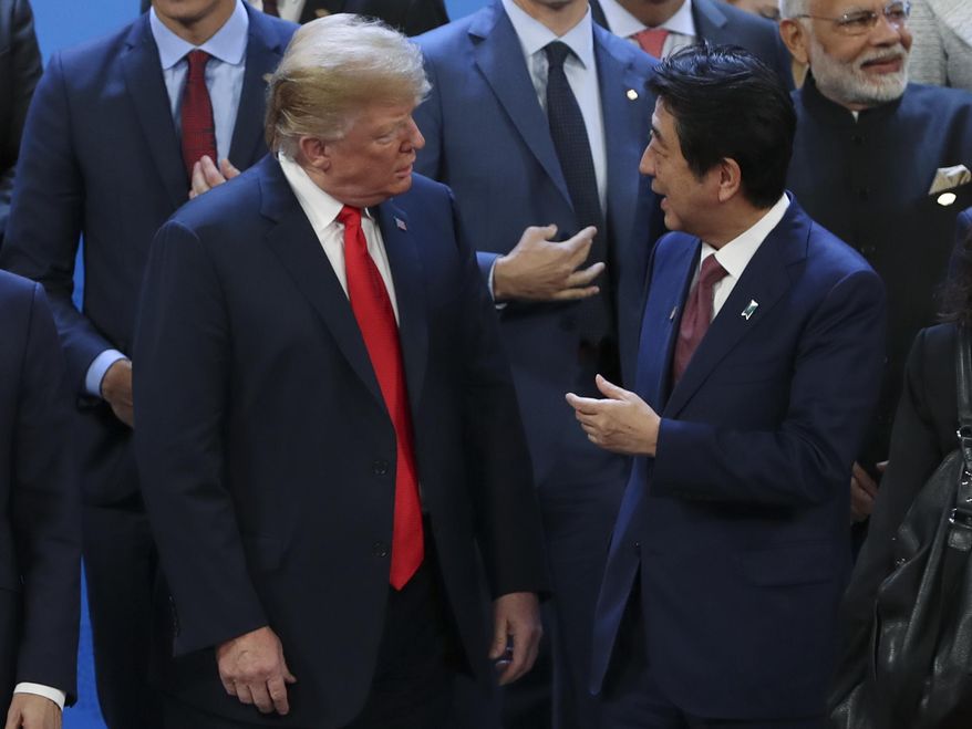 President Donald Trump, left, listens to Japan's Prime Minister Shinzo Abe as they wait for the family photo of the G-20 Leader's Summit at the Costa Salguero Center in Buenos Aires, Argentina, Friday, Nov. 30, 2018. (AP Photo/Ricardo Mazalan) ** FILE **