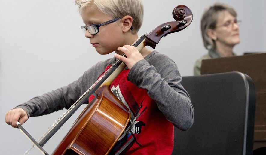 Carter Frey, left, the face of the new Nebraska tourism campaign, performs on his cello during a run through with accompanist Stacie Haneline on Thursday, Nov. 1, 2018, at the Omaha Conservatory of Music. (Francis Gardler/Lincoln Journal Star via AP)