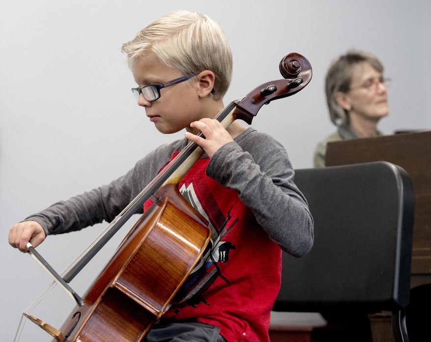 Carter Frey, left, the face of the new Nebraska tourism campaign, performs on his cello during a run through with accompanist Stacie Haneline on Thursday, Nov. 1, 2018, at the Omaha Conservatory of Music. (Francis Gardler/Lincoln Journal Star via AP)