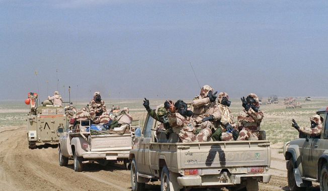 In this Feb. 24, 1991 file photo, Kuwaiti troops wear gas masks and protective suits as they roll through southern Kuwait in an armed motor convoy, the first full day of ground conflict in Operation Desert Storm. The inverted &amp;quot;V&amp;quot; painted on vehicles is the allied recognition symbol. In February 1991, after months of building an international coalition, U.S. forces entered Kuwait to end the Iraqi occupation of its smaller, oil-rich neighbor. (AP Photo/Laurent Rebours, File)