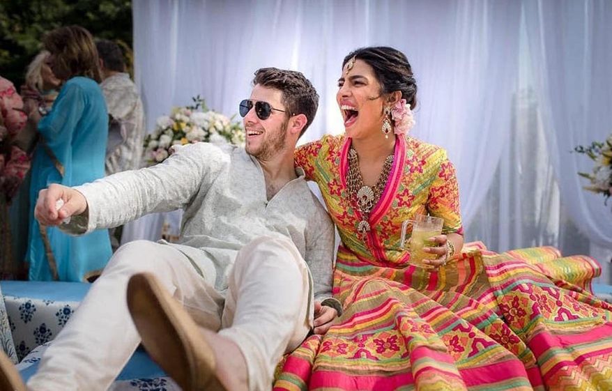 In this Friday, Nov. 30, 2018 handout photo released by Raindrop Media, Bollywood actress Priyanka Chopra and Nick Jonas celebrate during a mehendi ceremony, a day before their wedding, at Umaid Bhawan in Jodhpur, India. (Raindrop Media via AP)