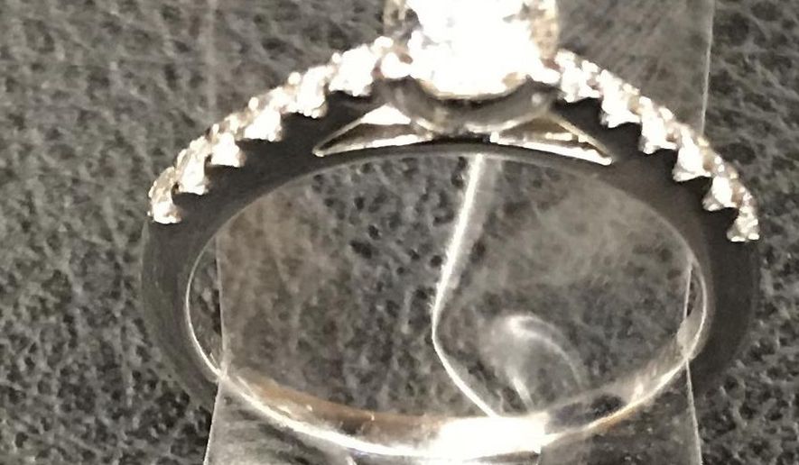 In this Dec. 1, 2018 photo provided by the New York City Police Department, an engagement ring recovered by the NYPD below a Times Square utility grate is shown in New York. Police say a man was proposing to his girlfriend just before midnight Friday when he dropped the ring and it fell about eight feet down a utility grate. Police were initially unable to find the ring on Friday night when the couple sought their assistance but located it Saturday morning. The couple did not leave their contact information and the NYPD would like to reunite them with their ring. (NYPD via AP)
