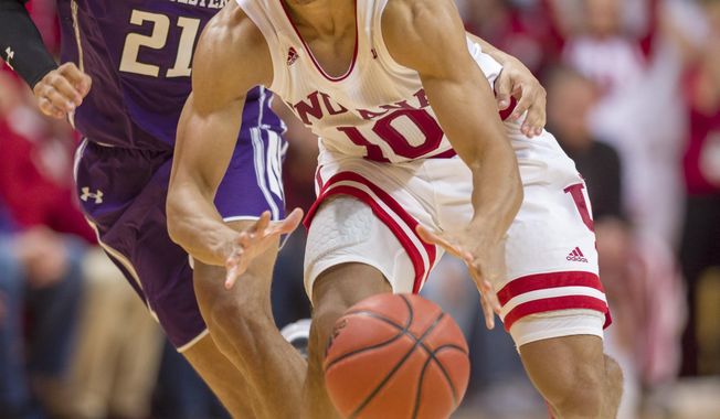 Indiana guard Rob Phinisee (10) makes a pass to a teammate after getting around the defense of Northwestern forward A.J. Turner (21) during the second half of an NCAA college basketball game Saturday, Dec. 1, 2018, in Bloomington, Ind. Indiana won 68-66. (AP Photo/Doug McSchooler)