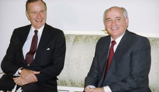 In this photo taken on Tuesday, Oct. 29, 1991, U.S. President George H. Bush, left, and Soviet President Mikhail Gorbachev sit together at the Soviet Embassy after meeting in Madrid, Spain. Former Soviet premier Mikhail Gorbachev expressed his &quot;deep condolences&quot; Saturday Dec. 1, 2018, to the family of former U.S President George Bush and all Americans following his death, age 94. (AP Photo/Liu Heung Shing, File)
