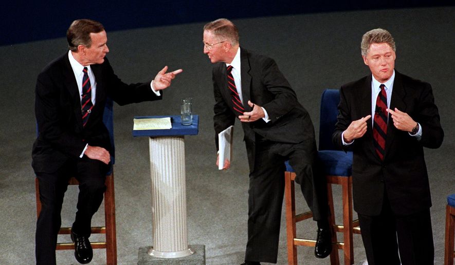 FILE - In this Oct. 15, 1992, file photo, President George H.W. Bush, left, talks with independent candidate Ross Perot as Democratic candidate Bill Clinton stands aside at the end of their second presidential debate in Richmond, Va. Bush died at the age of 94 on Friday, Nov. 30, 2018, about eight months after the death of his wife, Barbara Bush. (AP Photo/Marcy Nighswander, File)