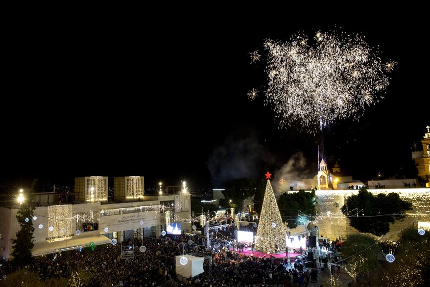 Palestinian Christians celebrate the lighting of a Christmas tree in Manger Square, outside the Church of the Nativity in the West Bank town of Bethlehem,, Saturday, Dec. 1, 2018.(AP Photo/Majdi Mohammed)