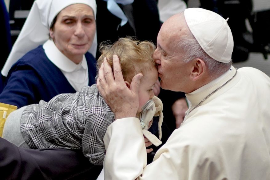 Pope Francis kisses a baby during an audience for members of the diocesis of Molfetta and Ugento-Santa Maria di Leuca, at the Vatican, Saturday, Dec. 1, 2018. (AP Photo/Andrew Medichini)