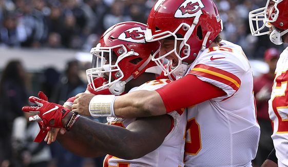 Kansas City Chiefs running back Spencer Ware, left, is congratulated by quarterback Patrick Mahomes after scoring against the Oakland Raiders during the second half of an NFL football game in Oakland, Calif., Sunday, Dec. 2, 2018. (AP Photo/Ben Margot)