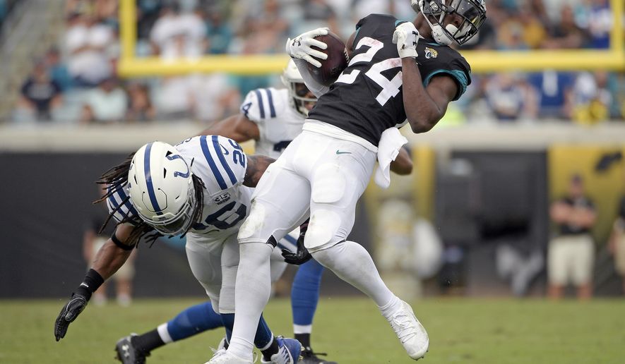 Jacksonville Jaguars running back T.J. Yeldon (24) breaks a tackle by Indianapolis Colts strong safety Clayton Geathers during the first half of an NFL football game, Sunday, Dec. 2, 2018, in Jacksonville, Fla. (AP Photo/Phelan M. Ebenhack)