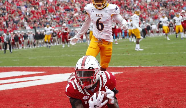 North Carolina State's Kelvin Harmon (3) hauls in a touchdown pass against East Carolina's Marcus Holton Jr. (6) during the first half of NCAA college football game in Raleigh, N.C., Saturday, Dec. 1, 2018. (AP Photo/Chris Seward)