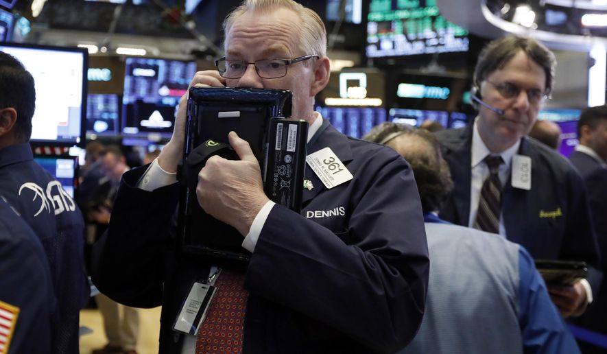 FILE- In this Thursday, Nov. 29, 2018, file photo trader Dennis Maguire, left, works on the floor of the New York Stock Exchange. The U.S. stock market opens at 9:30 a.m. EST on Monday, Dec. 3. (AP Photo/Richard Drew, File)