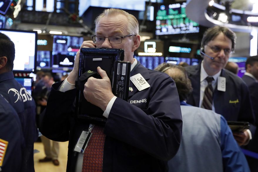 FILE- In this Thursday, Nov. 29, 2018, file photo trader Dennis Maguire, left, works on the floor of the New York Stock Exchange. The U.S. stock market opens at 9:30 a.m. EST on Monday, Dec. 3. (AP Photo/Richard Drew, File)