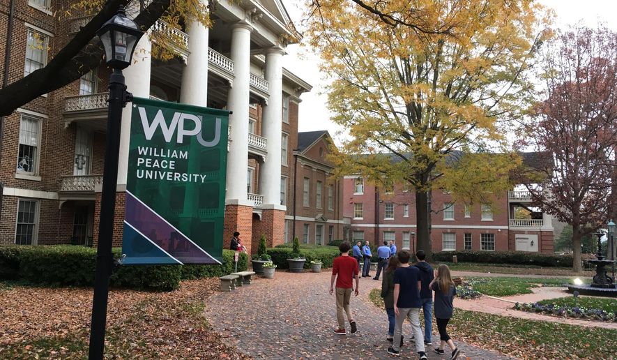 Students walk the William Peace University campus in Raleigh, N.C., Monday, Dec. 3, 2018. A report of a possible gunman at William Peace University's downtown Raleigh campus prompted the school to tell people shelter in place Monday. The president of the school later said police have determined there was no threat posed to the small liberal arts college after it went on alert earlier in the day to a report of a possible gunman. (AP Photo/Jonathan Drew)
