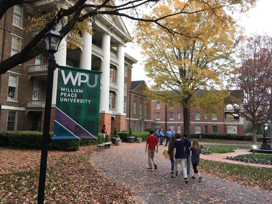 Students walk the William Peace University campus in Raleigh, N.C., Monday, Dec. 3, 2018. A report of a possible gunman at William Peace University's downtown Raleigh campus prompted the school to tell people shelter in place Monday. The president of the school later said police have determined there was no threat posed to the small liberal arts college after it went on alert earlier in the day to a report of a possible gunman. (AP Photo/Jonathan Drew)
