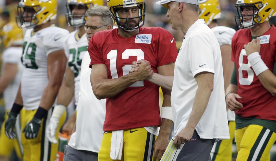 FILE - In this Aug. 4, 2018, file photo, Green Bay Packers quarterback Aaron Rodgers shakes hands with new offensive coordinator Joe Philbin during the NFL football team&#39;s Family Night practice in Green Bay, Wis. The Packers fired coach Mike McCarthy Sunday, Dec. 2, 2018, and made offensive coordinator Joe Philbin the interim head coach. (AP Photo/Mike Roemer, File)