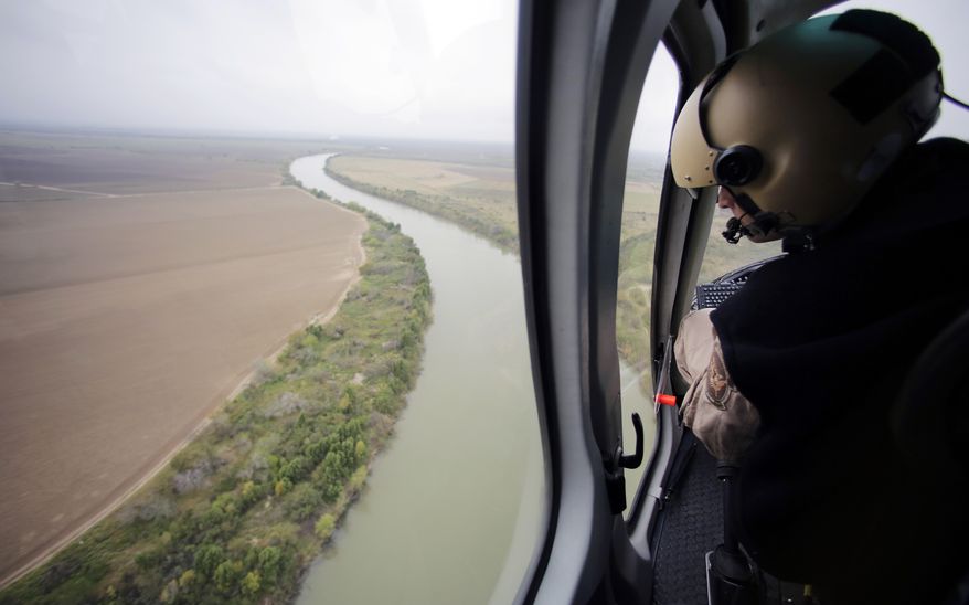 FILE - In this Tuesday, Feb. 24, 2015, aerial file photo, a U.S. Customs and Border Protection Air and Marine agent looks out along the Rio Grande on the Texas-Mexico border in Rio Grande City, Texas. U.S. Homeland Security Secretary Kirstjen Nielsen said Wednesday, April 4, 2018, that President Donald Trump and border-state governors are working to immediately deploy the National Guard to the U.S.-Mexico border to fight illegal immigration. (AP Photo/Eric Gay, File)