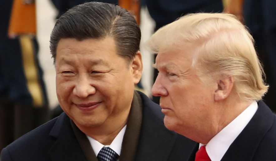 In this Nov. 9, 2017, file photo, U.S. President Donald Trump and Chinese President Xi Jinping participate in a welcome ceremony at the Great Hall of the People in Beijing, China. (AP Photo/Andrew Harnik, File)