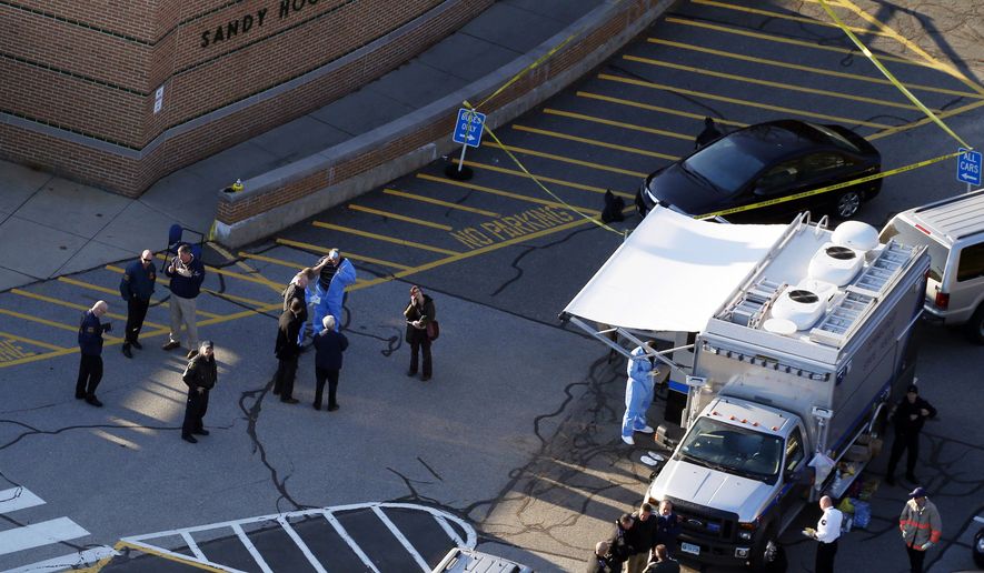 Officials are on the scene outside of Sandy Hook Elementary School in Newtown, Conn., where authorities say a gunman opened fire inside an elementary school in a shooting that left 27 people dead, including 20 children, Friday, Dec. 14, 2012. (AP Photo/Julio Cortez)