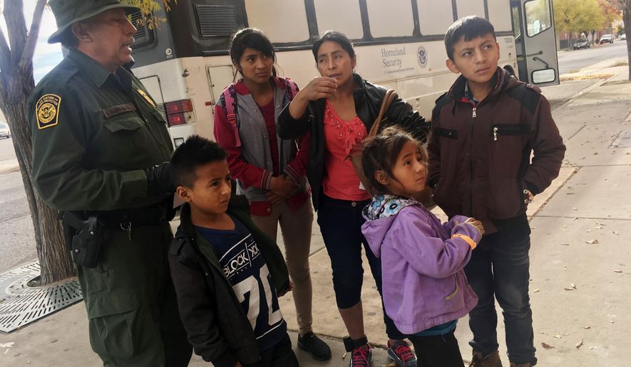 In this Thursday, Nov. 29, 2018, file photo, a migrant family from Central America waits outside the Annunciation House shelter in El Paso, Texas, after a U.S. Immigration and Customs Enforcement officer drops them off. (AP Photo/Russell Contreras) ** FILE **
