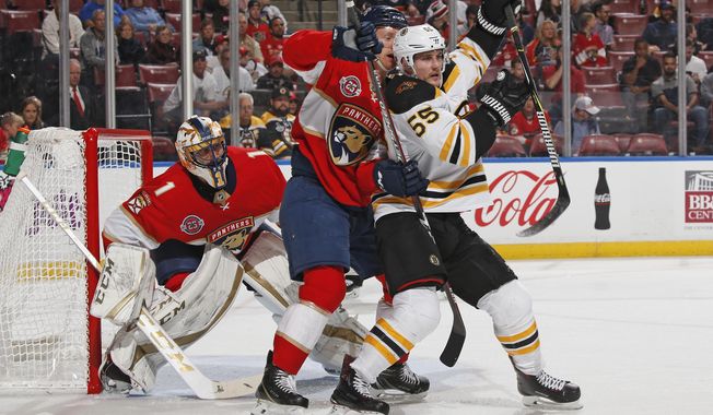 Florida Panthers goaltender Roberto Luongo (1) fends the net as Florida Panthers defenseman Michael Matheson (19) battles for position with Boston Bruins center Noel Acciari (55) during the second period of an NHL hockey game, Tuesday, Dec. 4, 2018, in Sunrise, Fla. (AP Photo/Joel Auerbach)