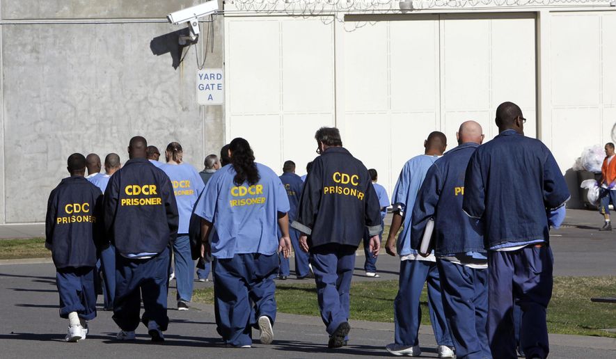FILE - In this Feb. 26, 2013, file photo, inmates walk through the exercise yard at California State Prison Sacramento, near Folsom, Calif. California arrest rates have dropped nearly 60 percent since 1989, yet blacks are three times more likely to be arrested than whites, according to a report released by the Public Institute of California, Monday Dec. 3, 2018. (AP Photo/Rich Pedroncelli, File)