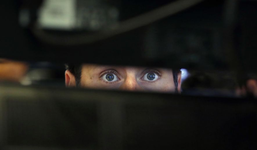 FILE- In this Nov. 28, 2018, file photo specialist Michael Pistillo watches the screens at his post on the floor of the New York Stock Exchange. One of the most reliable warning signals for recession just got a bit brighter. It lies in the bond market, and when it’s turned on at full-brightness, it has preceded every one of the U.S. economy’s recessions for more than half a century. (AP Photo/Richard Drew, File)