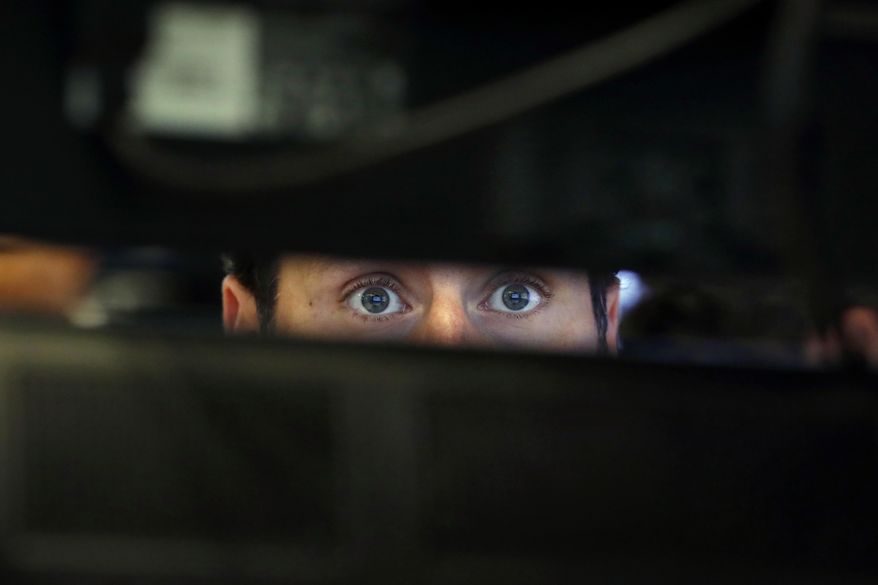 FILE- In this Nov. 28, 2018, file photo specialist Michael Pistillo watches the screens at his post on the floor of the New York Stock Exchange. One of the most reliable warning signals for recession just got a bit brighter. It lies in the bond market, and when it’s turned on at full-brightness, it has preceded every one of the U.S. economy’s recessions for more than half a century. (AP Photo/Richard Drew, File)